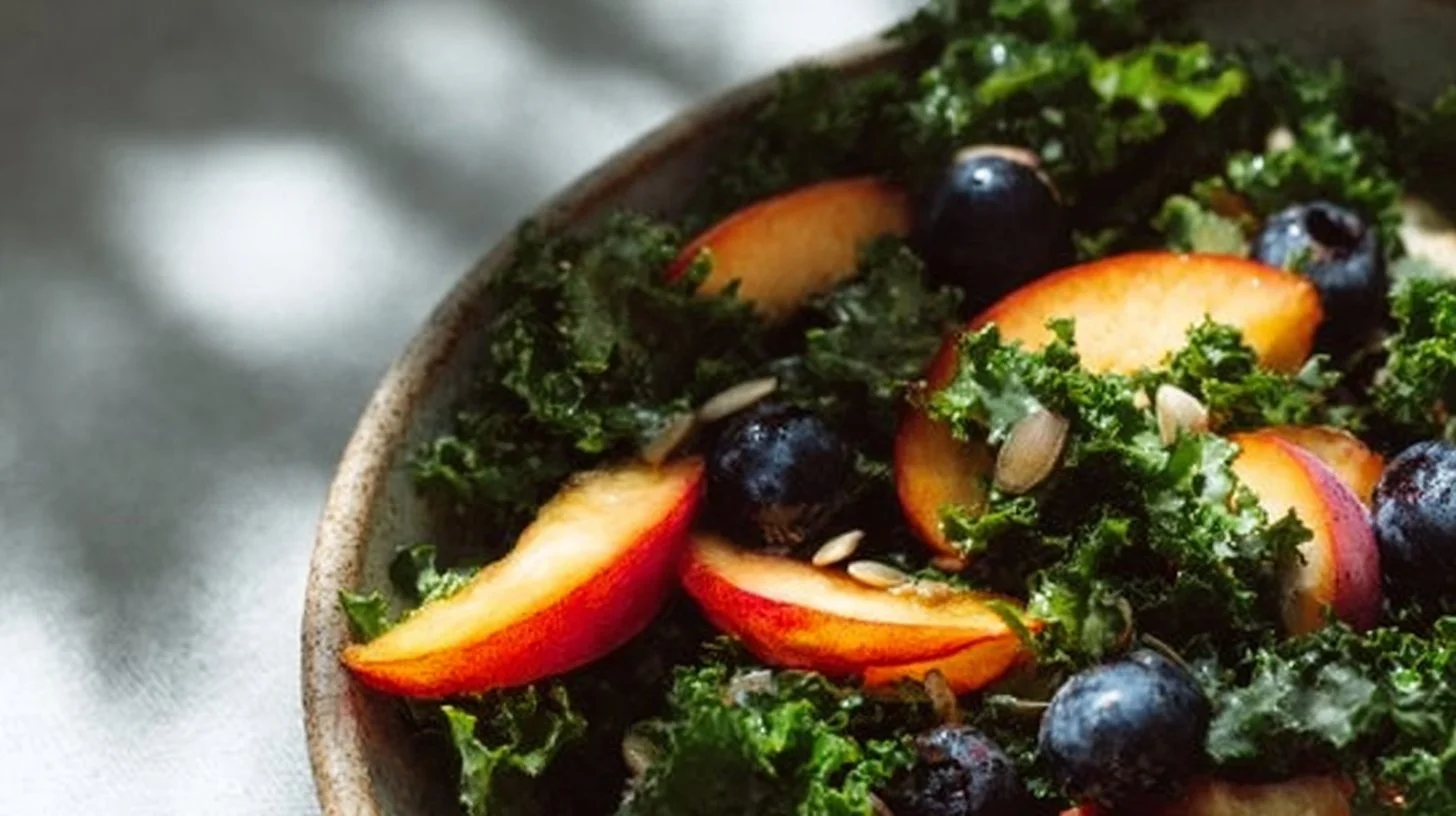 Peach and blueberry kale salad with fresh ingredients and vibrant colors.